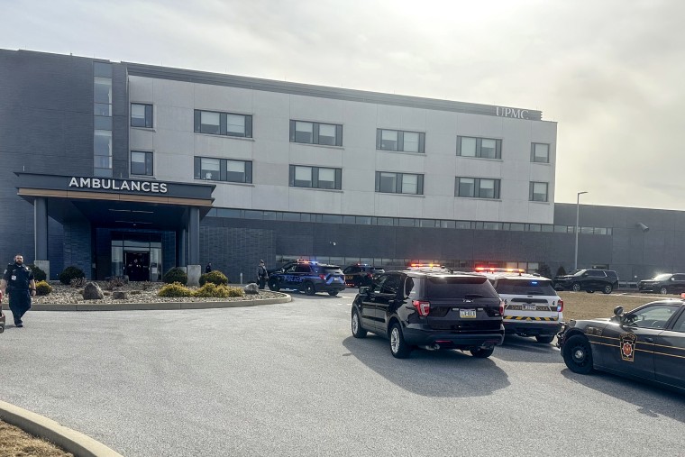 Emergency response vehicles outside a hospital during a critical incident.