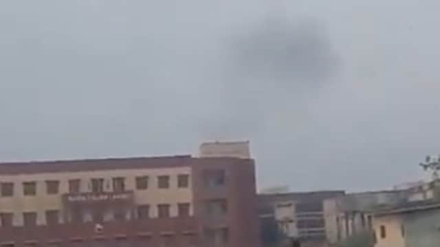 Smoke rises over Lahore city with crowds on the streets