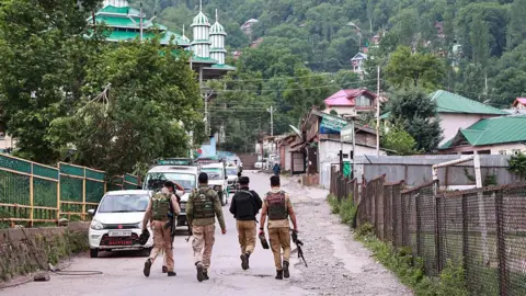 Aftermath of Kashmir terror attack with damaged building and security personnel