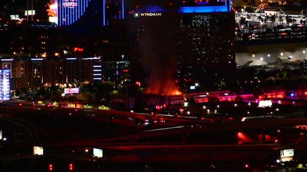Fire crews respond to the Las Vegas fire near the Strip. The image shows flames and emergency vehicles at the scene.