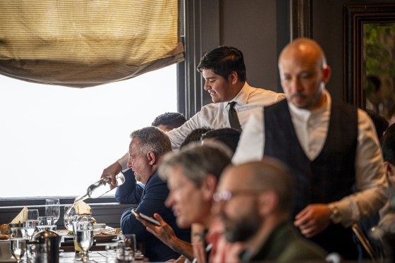 A group of American workers discussing their paychecks with the no tax on overtime bill in effect.